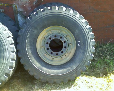 1978 Chevrolet C/K Pickup - Several large truck tires are stacked outdoors, with a wooden structure in the background.