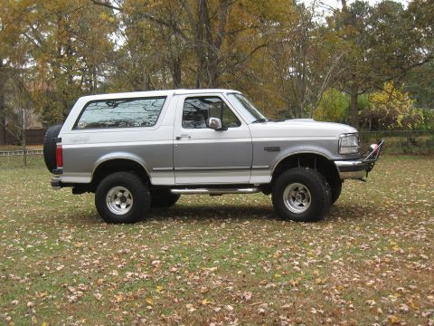 1994 Ford Bronco - Side view of a two-tone Ford Bronco, showing its body style and off-road tires.