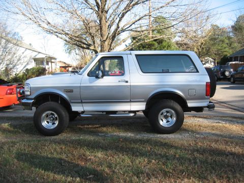 1994 Ford Bronco - This two-tone silver 1994 Ford Bronco is shown from the side, aftermarket wheels and side steps.