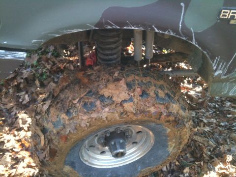 1995 Ford Bronco - Muddy wheel and suspension of a 1995 Ford Bronco after off-roading.