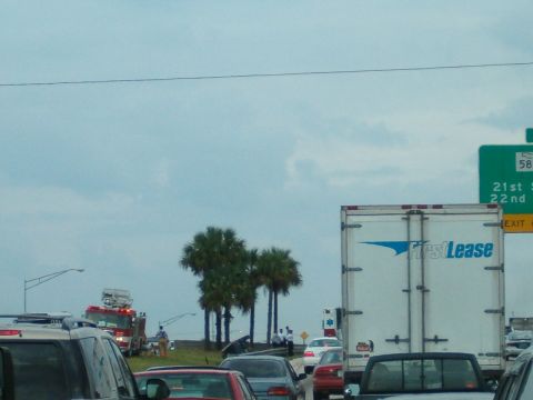 1991 Ford Bronco - A traffic scene unfolds on a highway, a fire truck and various other vehicles under a cloudy sky.