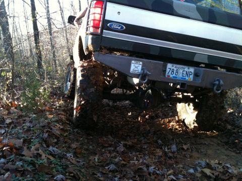 1995 Ford Bronco - A heavily modified 1992 Ford Bronco navigates a muddy, wooded path.