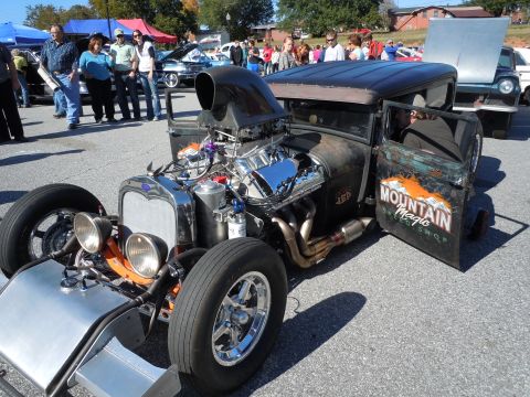 1982 Chevrolet Camaro - A heavily modified hot rod with an exposed engine and custom door art is on display at an outdoor event.