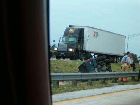 1991 Ford Bronco - A UPS semi-truck is parked next to an overturned pickup truck, with emergency responders on the scene.