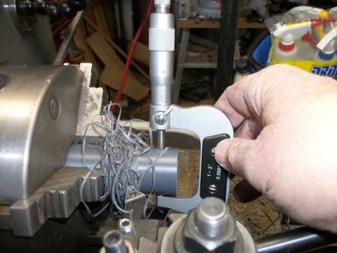 1996 Ford Bronco - A micrometer is used to measure the diameter of a metal rod being worked on a lathe.
