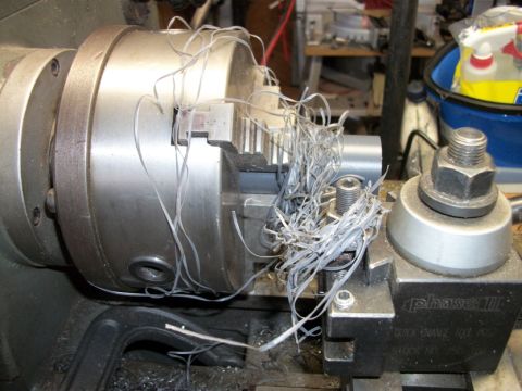 1996 Ford Bronco - Metal shavings accumulate on a lathe chuck and tool post, obscuring the machining process.