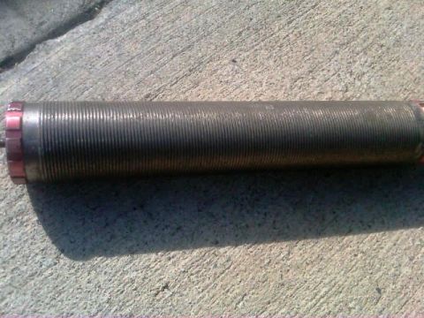 1986 Ford Bronco - A shock absorber part is shown on a concrete surface.