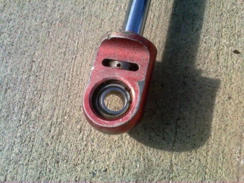 1986 Ford Bronco - A red metal component with a visible bearing is shown against a concrete surface.