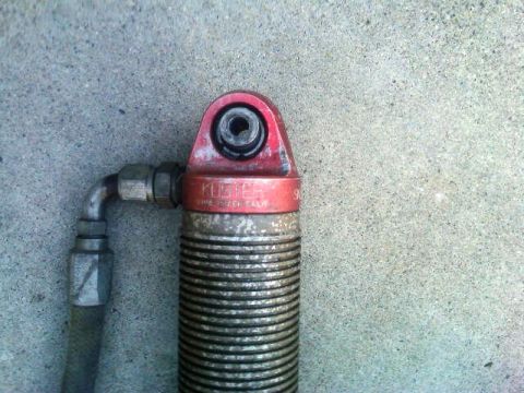 1986 Ford Bronco - A close-up view of a Kuster shock absorber part, showing its construction and branding.