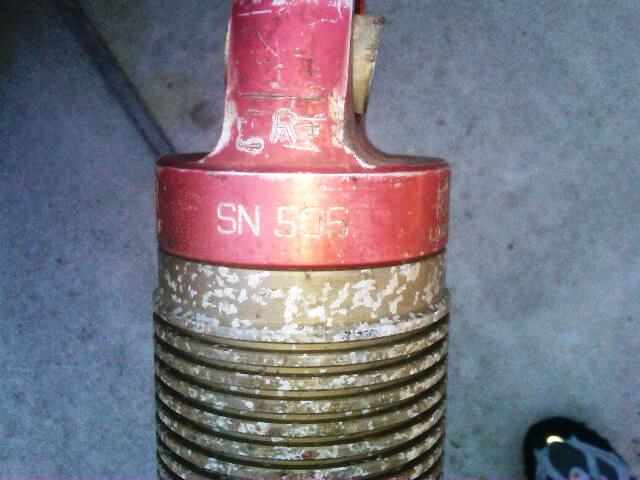 Red and brass part with SN 505 visible