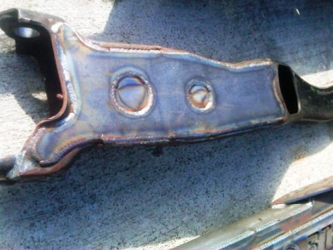 1986 Ford Bronco - A close-up view of a modified suspension component, likely for off-road use, showing extensive welding and metalwork.