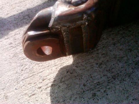 1986 Ford Bronco - Close-up of a rusty metal suspension part with visible welds and a bolt hole.