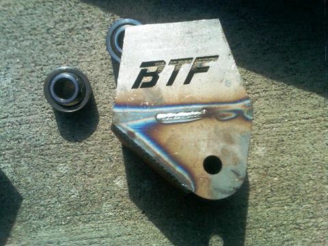 1986 Ford Bronco - BTF suspension bracket with two bearings shown on a concrete surface.