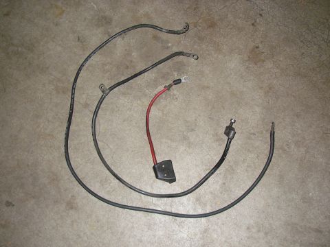 1990 Ford Bronco - Automotive battery cables laid out on a concrete surface.
