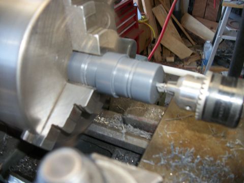 1996 Ford Bronco - A gray cylindrical part is being machined on a metal lathe, with metal shavings visible.
