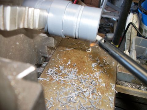 1996 Ford Bronco - A metal pipe is being cut on a lathe, with metal shavings scattered around the work area.