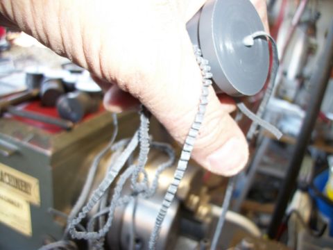 1996 Ford Bronco - A hand holds a gray cylindrical object with a cord, with machinery visible in the background.