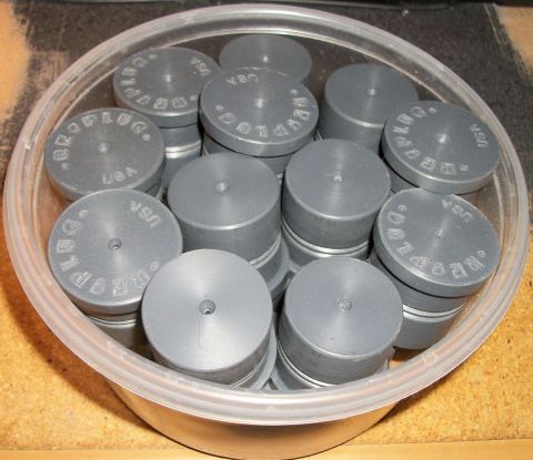 1996 Ford Bronco - A collection of gray plugs, each stamped with 'BROPLUG' and 'USA', are stored in a clear plastic container.