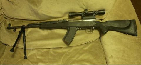 2000 Mercury Grand Marquis - A rifle with a scope and bipod is displayed on a couch.
