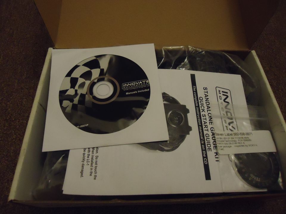 Innovate Motorsports standalone gauge kit in an open box with a CD and quick start guide