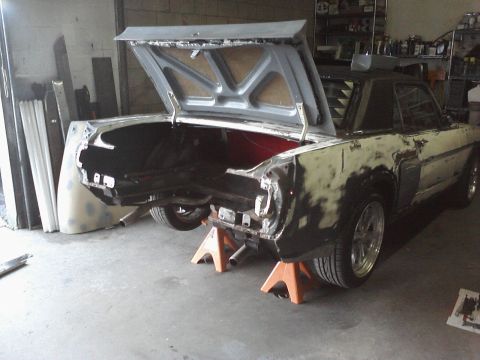 1966 Ford Mustang - This 1966 Ford Mustang is in a repair shop with its trunk open and rear end elevated on jack stands.