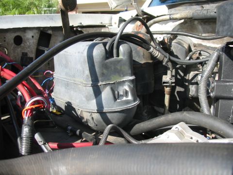 1992 Ford Bronco - Close-up view of the engine bay, focusing on the vacuum reservoir and associated wiring.