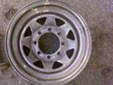 1989 Ford Bronco - A close-up view of a silver steel wheel, likely from a truck or SUV, with a multi-lug pattern.