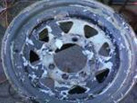 1989 Ford Bronco - Close-up of a damaged steel wheel rim, showing signs of wear and tear.