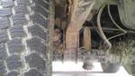 1989 Ford Bronco - A close-up view of a vehicle's suspension system and tire, showing signs of rust and wear.