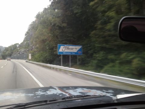 1989 Ford Bronco - A view from inside a vehicle shows a sign for Tennessee on a highway with trees in the background.