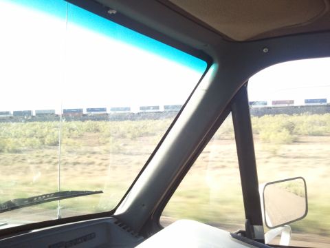 1989 Ford Bronco - View from inside a vehicle shows a train passing by in the distance.