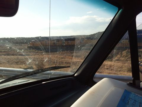 1989 Ford Bronco - View from inside a vehicle shows a train passing by in the distance.