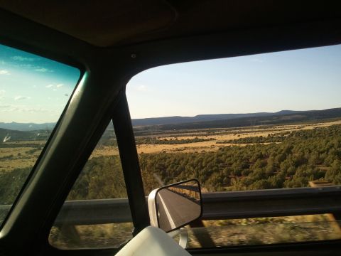 1989 Ford Bronco - View from inside a vehicle as it travels through a scenic, rural area with rolling hills and scattered trees.