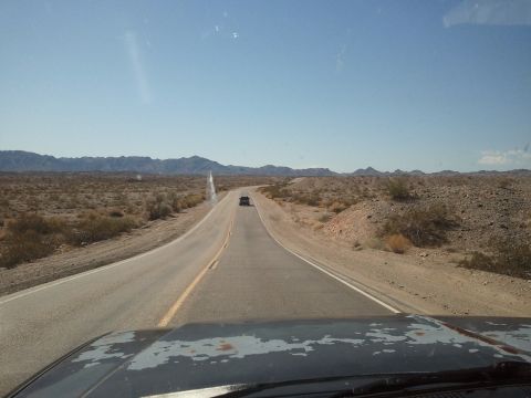 1989 Ford Bronco - Driving on a highway through a desert landscape with mountains in the distance.