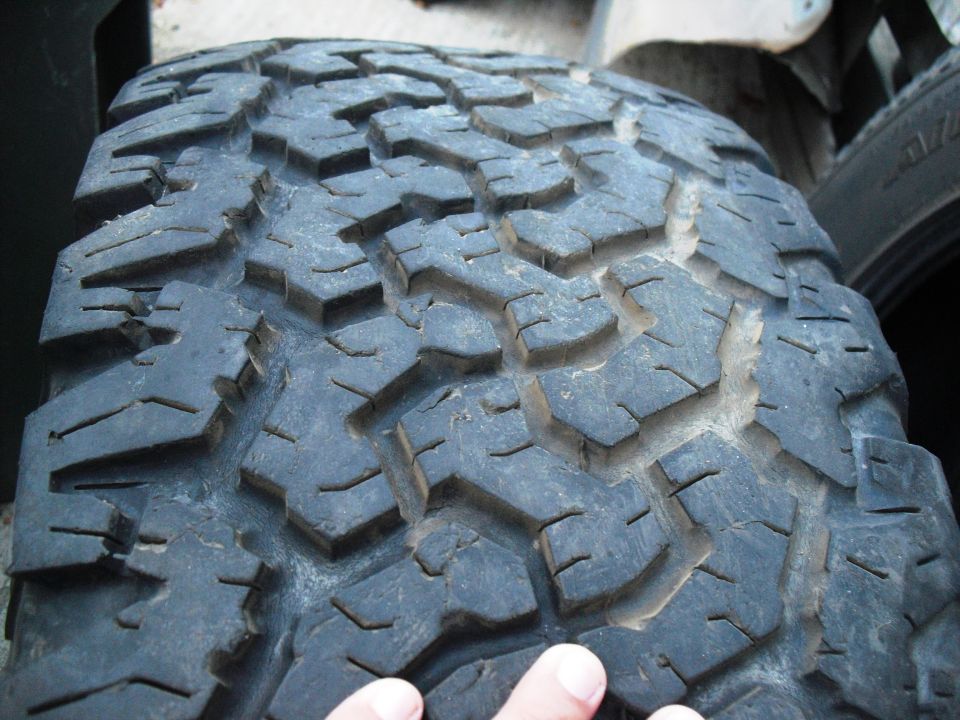 Close-up of a worn tire tread with large, aggressive lugs