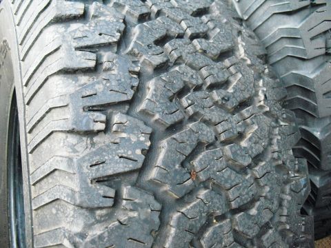 1986 Ford Bronco - The image shows a detailed view of the tread on an off-road tire, highlighting its aggressive design.