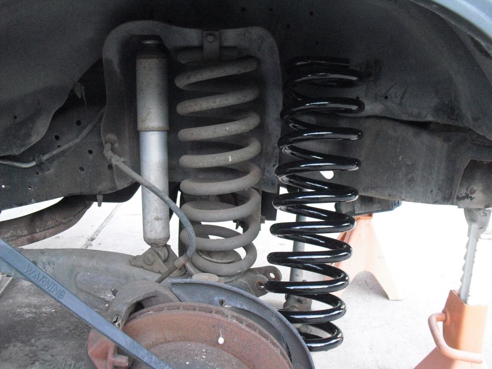 Comparison of old and new suspension coil springs with shock absorber
