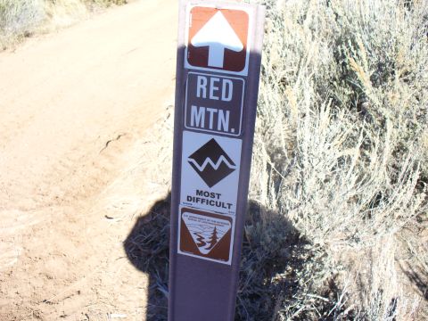 1979 Ford Bronco - A trail marker sign displays directions for Red Mountain, noting the trail difficulty as 'Most Difficult'.