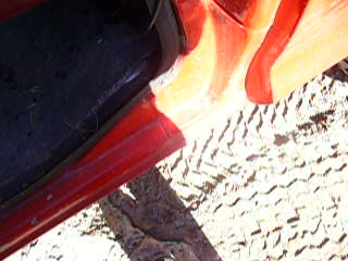 1979 Ford Bronco - Detail shot of a red vehicle's door edge and interior, with a watermark from SuperMotors.net.