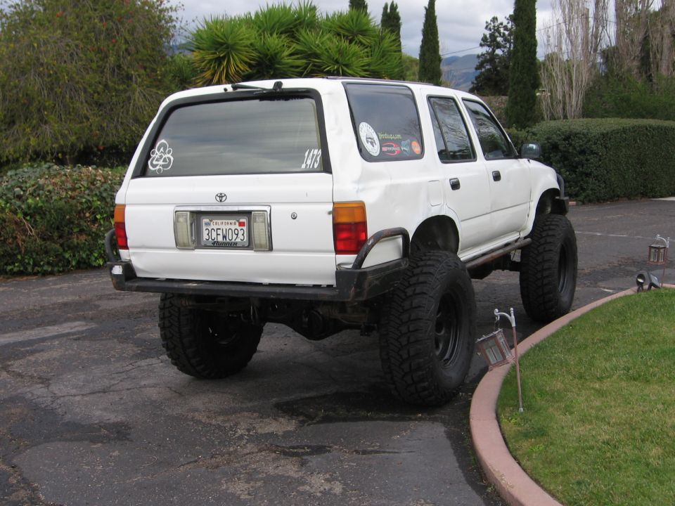 1993 Toyota 4Runner rear view, white, lifted with large tires and custom bumper