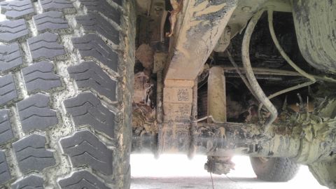 1989 Ford Bronco - The undercarriage of a heavily soiled vehicle, showing the tire and suspension components.
