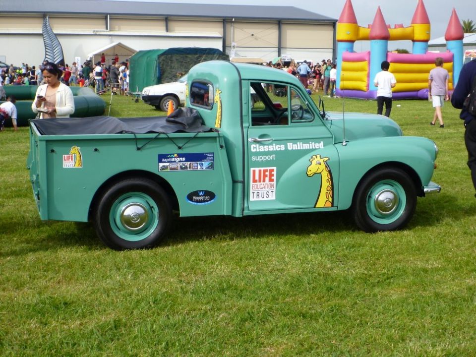Green pickup truck with giraffe decals and 'Classics Unlimited support LIFE EDUCATION TRUST' text
