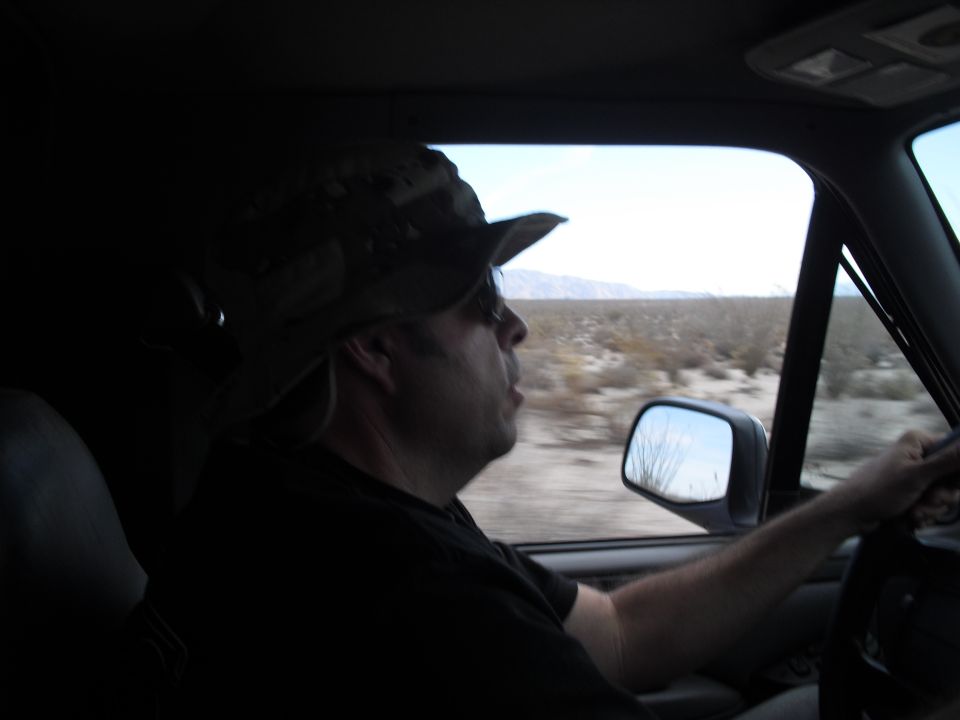 Man driving a vehicle through a desert landscape