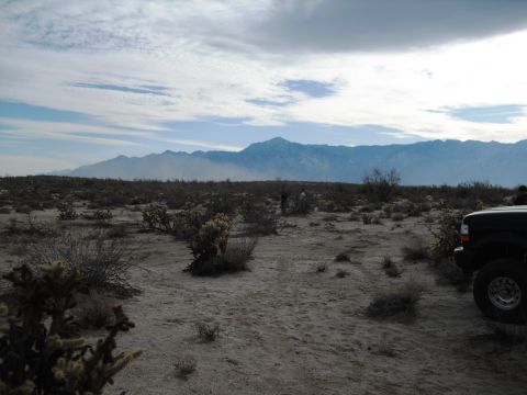 1986 Ford Bronco - A vehicle sits in a dry, arid environment under a cloudy sky with distant mountains.
