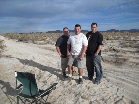 1986 Ford Bronco - Three men pose for a photo in a dry, desert environment under a cloudy sky.