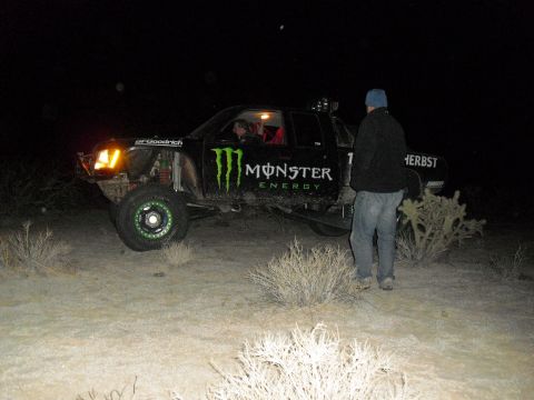 1986 Ford Bronco - A custom off-road truck sponsored by Monster Energy is seen at night in a desert landscape.