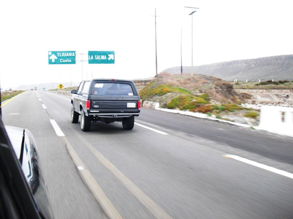 Black Ford Bronco driving on highway, signs for Tijuana and La Salina visible