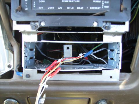 1979 Ford F-100 - Close-up of car radio wiring and mounting bracket, showing disconnected wires and connectors.