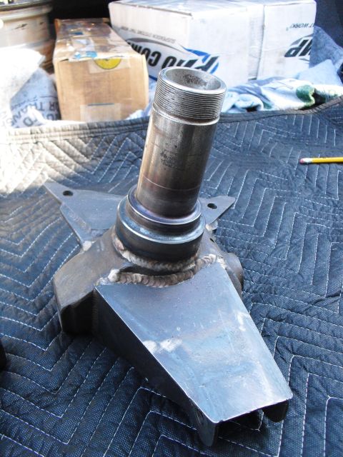 1986 Ford Bronco - A close-up view of a metal spindle assembly, likely a replacement part, is shown on a quilted surface.