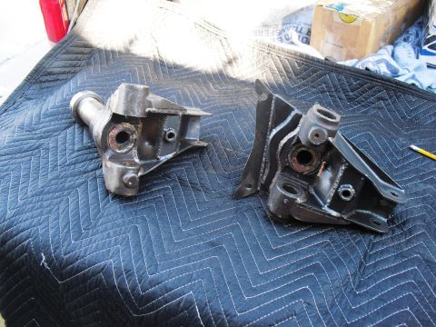 1986 Ford Bronco - Two heavy-duty metal components, likely from a vehicle's front axle, are laid out on a protective mat.